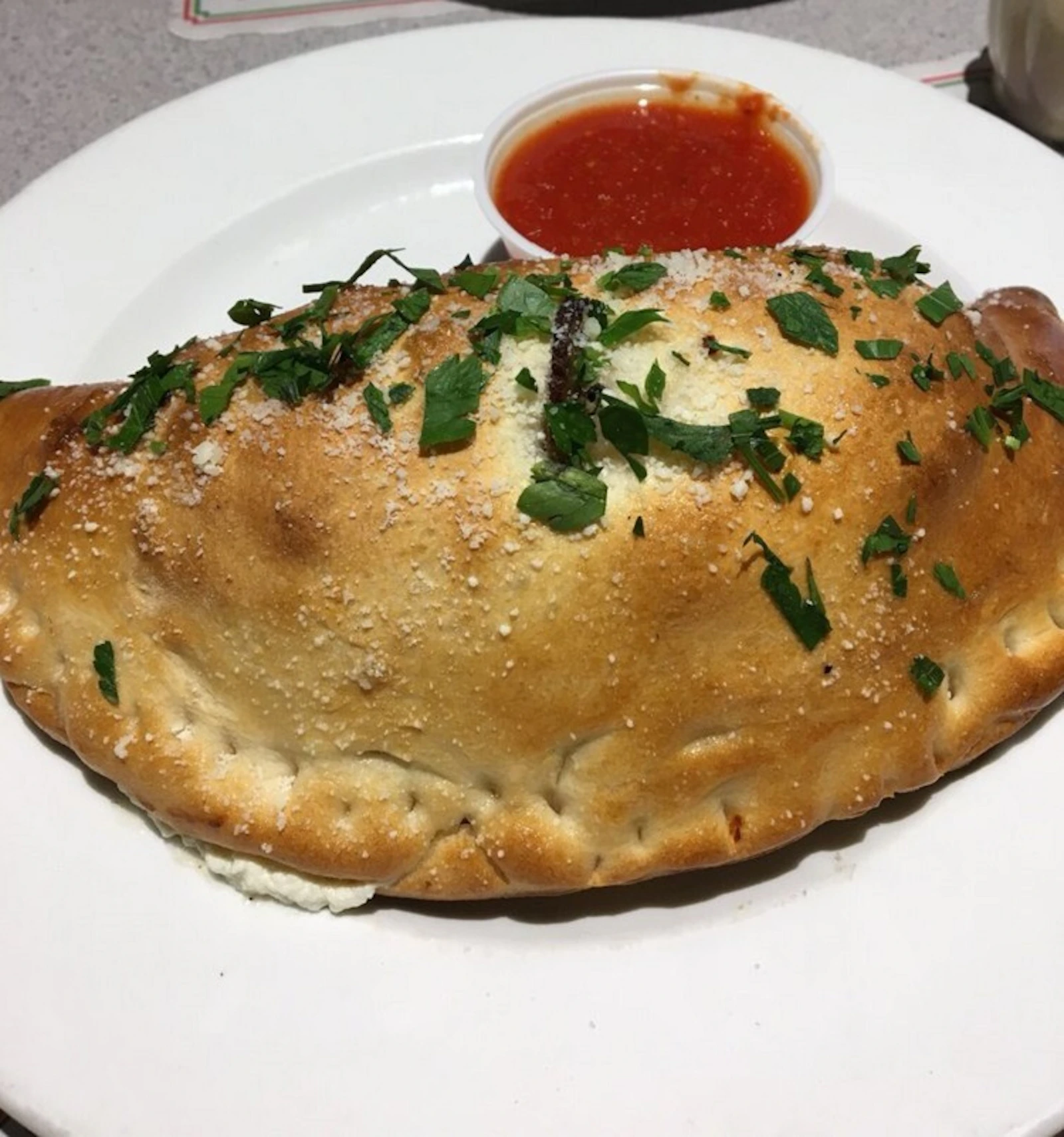 Golden calzone served with marinara from Our Little Italy